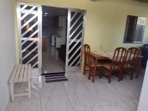 a dining room with a table and chairs and a door at Casa com 2 quartos in Rio das Ostras +1 photo
