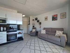 a living room with a couch and a kitchen at Sol del Sur Ocean View in Puerto de Santiago
