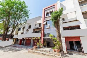 an apartment building with trees in front of it at Hotel O Sachin Residency in Nashik