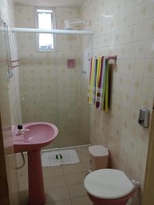 ein Badezimmer mit einem rosa Waschbecken und einer Dusche in der Unterkunft Apartamento 20m Parque do Povo in Campina Grande + 7 Fotos