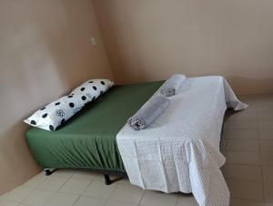 ein grünes Bett mit Handtüchern auf dem Zimmer in der Unterkunft Apartamento 20m Parque do Povo in Campina Grande