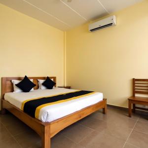a bedroom with a bed and a air conditioner on the wall at Sewwandi Guest House in Arugam Bay