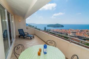 een balkon met een tafel en uitzicht op de stad bij Apartments Simic in Dubrovnik