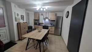 a kitchen with a wooden table and a refrigerator at Le Bedugue in Dole