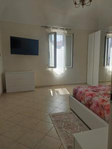 ein Schlafzimmer mit einem Bett und einem Flachbildfernseher in der Unterkunft Casa vacanze Nonna Anna in Montesilvano