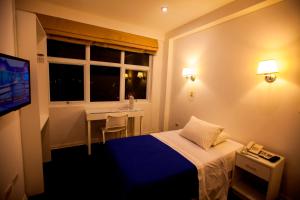 a hotel room with a bed and a table and a window at Hotel Gran Palma Huancayo in Huancayo