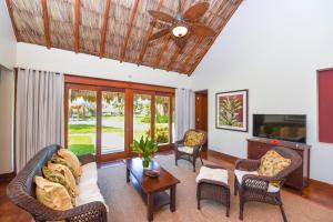 a living room with a ceiling fan and chairs at Victoria House Resort & Spa in San Pedro