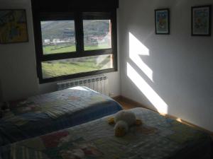 un osito de peluche sentado en una cama en un dormitorio en Apartamento Duplex en Ezcaray, en Zorraquín