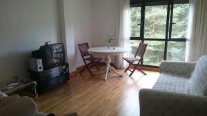 sala de estar con mesa, sillas y TV en Apartamento Duplex en Ezcaray, en Zorraquín