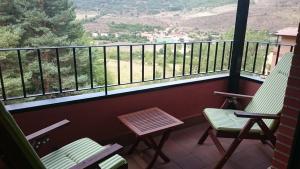 2 sillas y mesa en un balcón con vistas en Apartamento Duplex en Ezcaray, en Zorraquín