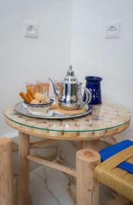 einen Tisch mit einer Teekanne und Keksen darauf in der Unterkunft Studio Blue Majorelle Marrakech in Marrakesch