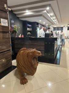 a statue of a dog in a restaurant lobby at Havana Palace Hotel II Uberaba in Uberaba