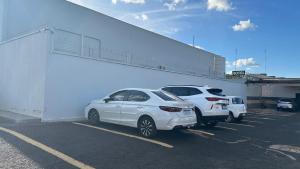 two cars parked in a parking lot next to a building at Havana Palace Hotel II Uberaba in Uberaba