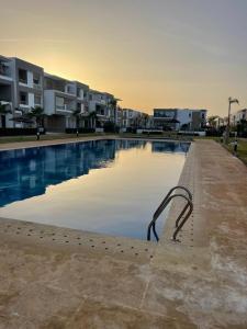 a swimming pool in a city with buildings in the background at Appartement Luxueux Mer & Piscine in Mansouria