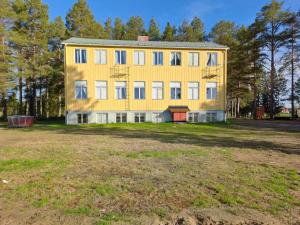 un grande edificio giallo su un prato di Skolan a Gargnäs