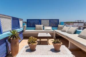 a balcony with couches and potted plants on a roof at The Chill Art Hostel in Essaouira