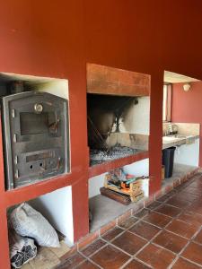a kitchen with an oven in a red wall at Casa de Campo Urqukunapi Wasi in San Salvador de Jujuy