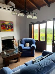 a living room with two blue couches and a fireplace at Casa de Campo Urqukunapi Wasi in San Salvador de Jujuy
