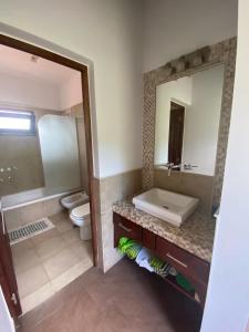 a bathroom with a sink and a toilet and a mirror at Casa de Campo Urqukunapi Wasi in San Salvador de Jujuy
