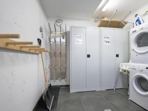 a laundry room with white cabinets and a washer and dryer at BergbiberHAUS Top A in Piesendorf