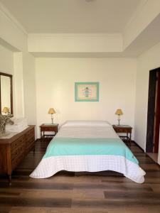 una camera da letto con un letto grande e due comodini di Casa 9 de julio a Tandil