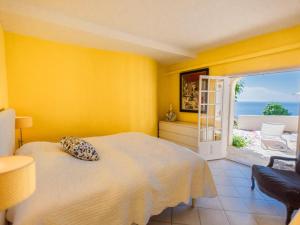 a yellow bedroom with a bed and a balcony at Lessix in Saint-Peïre-sur-Mer +36 photos