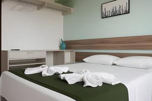 a bedroom with a bed with white sheets and pillows at Resort beira-mar Porto Galinhas in Porto De Galinhas +21 photos