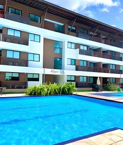 an apartment building with a swimming pool in front of it at Resort beira-mar Porto Galinhas in Porto De Galinhas