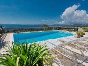 a swimming pool with chairs and a view of the ocean at Lessix in Saint-Peïre-sur-Mer