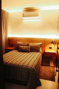 a bedroom with a bed with a light above it at Apartamento novo e aconchegante in Dourados