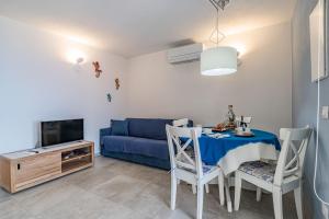 a living room with a table and a blue couch at Tra il Borgo e il Mare - Bel Horizonte in Capoliveri