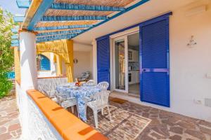 a table and chairs on the porch of a house at Tra il Borgo e il Mare - Bel Horizonte in Capoliveri