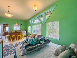a green room with a bed and a living room at Best Ocean Views from Guesthouse in Hawaiian Ocean View Estates