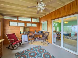 a living room with a ceiling fan and a table and chairs at Best Ocean Views from Guesthouse in Hawaiian Ocean View Estates