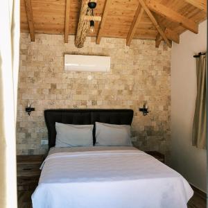 Bett in einem Zimmer mit Ziegelwand in der Unterkunft Mountain View House with Pool Near Olympos Adrasan in Kumluca