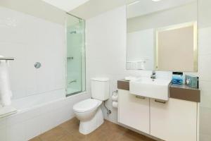 a bathroom with a toilet and a sink and a shower at Quest Maitland in Maitland