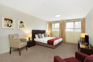 a hotel room with a bed and a chair at Quest Maitland in Maitland