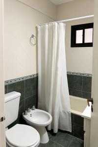 a bathroom with a toilet and a shower curtain at Rincón del mar in Mar del Plata