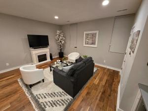 a living room with a black couch and a fireplace at Welcome to Luigi! in Omaha