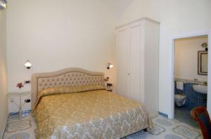 a bedroom with a bed and a bathroom with a sink at B&B Palazzo Pisani in Amalfi