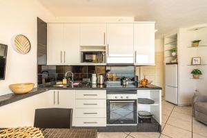 a kitchen with white cabinets and a stove at Sol del Sur Ocean View in Puerto de Santiago +64 photos