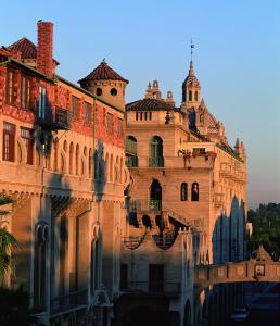 an old building with a reflection in the water at The Mission Inn Hotel and Spa in Riverside
