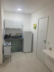 a kitchen with a white refrigerator and a sink at Apartamento Praia Bela Vista in Angra dos Reis