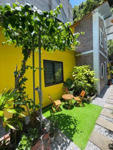 カットバ島にあるỐc Homestay Cát Bàの小さな庭園(テーブル、椅子付)