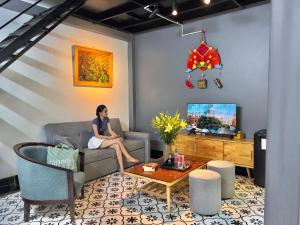 カットバ島にあるỐc Homestay Cát Bàの居間のソファに座る女性