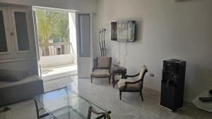 un salon avec une table en verre et des chaises dans l'établissement شاليه جرين بيتش العلمين ثلاث غرف, à El Alamein