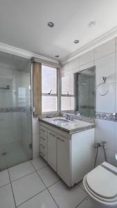 a bathroom with a sink and a shower and a toilet at Confortável apartamento in Jataí