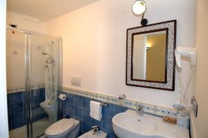 a bathroom with a toilet, sink and mirror at B&B Palazzo Pisani in Amalfi