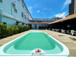 a swimming pool in the middle of a courtyard at Hotel Estação de Minas in Aparecida