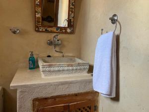 a bathroom sink with a white towel hanging on a wall at Tenasbook Rayhane in Midoun +62 photos